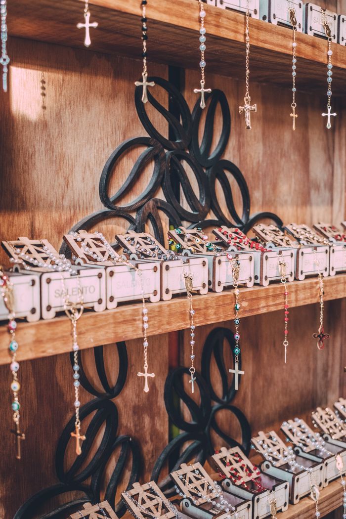 Vibrant rosaries on wooden shelves, showcasing Colombian craftsmanship in Salento.